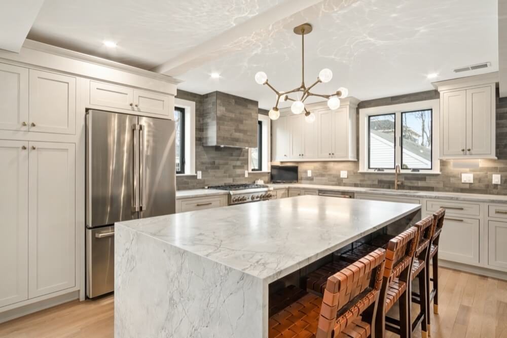 Kitchen island with quartz waterfall-edge countertop and contrasting cabinetry
